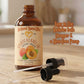 Bottle of apricot kernel oil with a dropper and pump on a wooden surface