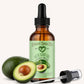 Bottle of avocado oil with a dropper and an avocado next to it on a white background