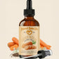 Bottle of Natural Barn Oils Carrot Seed Oil with carrots and seeds on a beige background