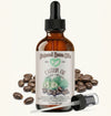 Bottle of Natural Born Oils castor oil with dropper and beans on a white background