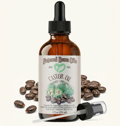 Bottle of Natural Born Oils castor oil with dropper and beans on a white background