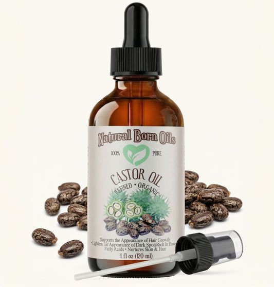 Bottle of Natural Born Oils castor oil with dropper and beans on a white background