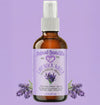 Bottle of Natural Born Oils lavender water spray on a purple background with lavender flowers.