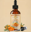 Bottle of Natural Born Oils Sea Buckthorn Oil with a dropper on a beige background