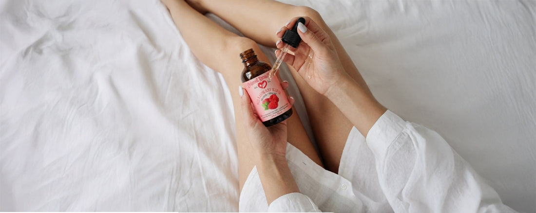 Person applying a skincare product to their leg with a dropper bottle.